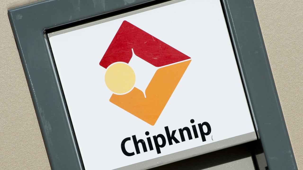Bord met Chipknip-logo in rood en oranje aan de gevel bij een betaalpunt.