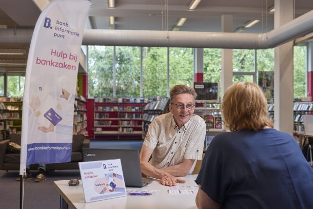 foto van twee mensen bij een Bankinformatiepunt in een bibliotheek