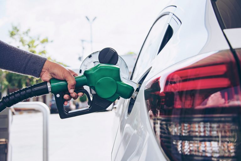 Driver refuels a car at a self-service petrol pump.