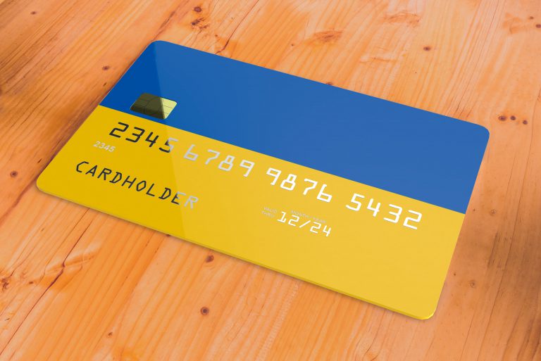 Payment cards and Ukrainian banknotes, illustrating payment options for refugees from Ukraine.