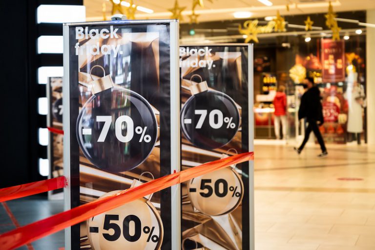 Shopping bags and Black Friday signage illustrating seasonal retail spending.