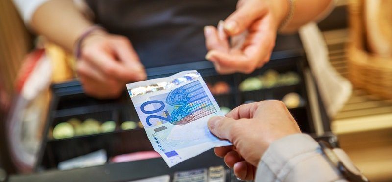 foto van iemand die met een biljet van €20 betaalt