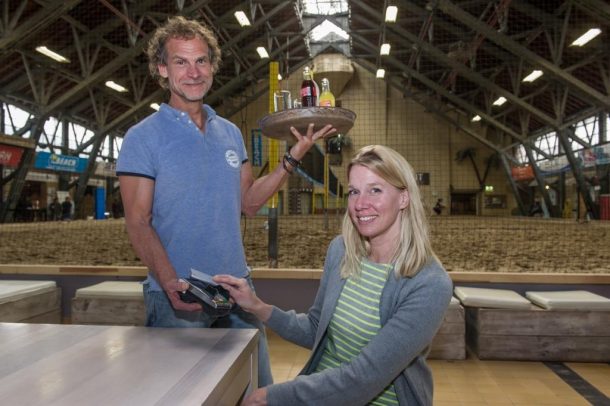 Arthur Wingelaar holds a tray while Freia Goederaad makes a contactless mobile payment at The Beach in Aalsmeer.
