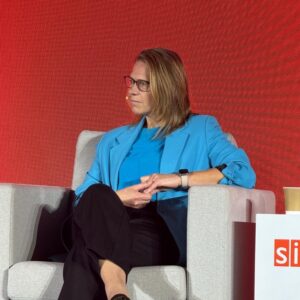 Erica Kostelijk, werkzaam in Transaction Banking bij ABN AMRO, zit aandachtig in een fauteuil tijdens een panelgesprek op een professioneel evenement.