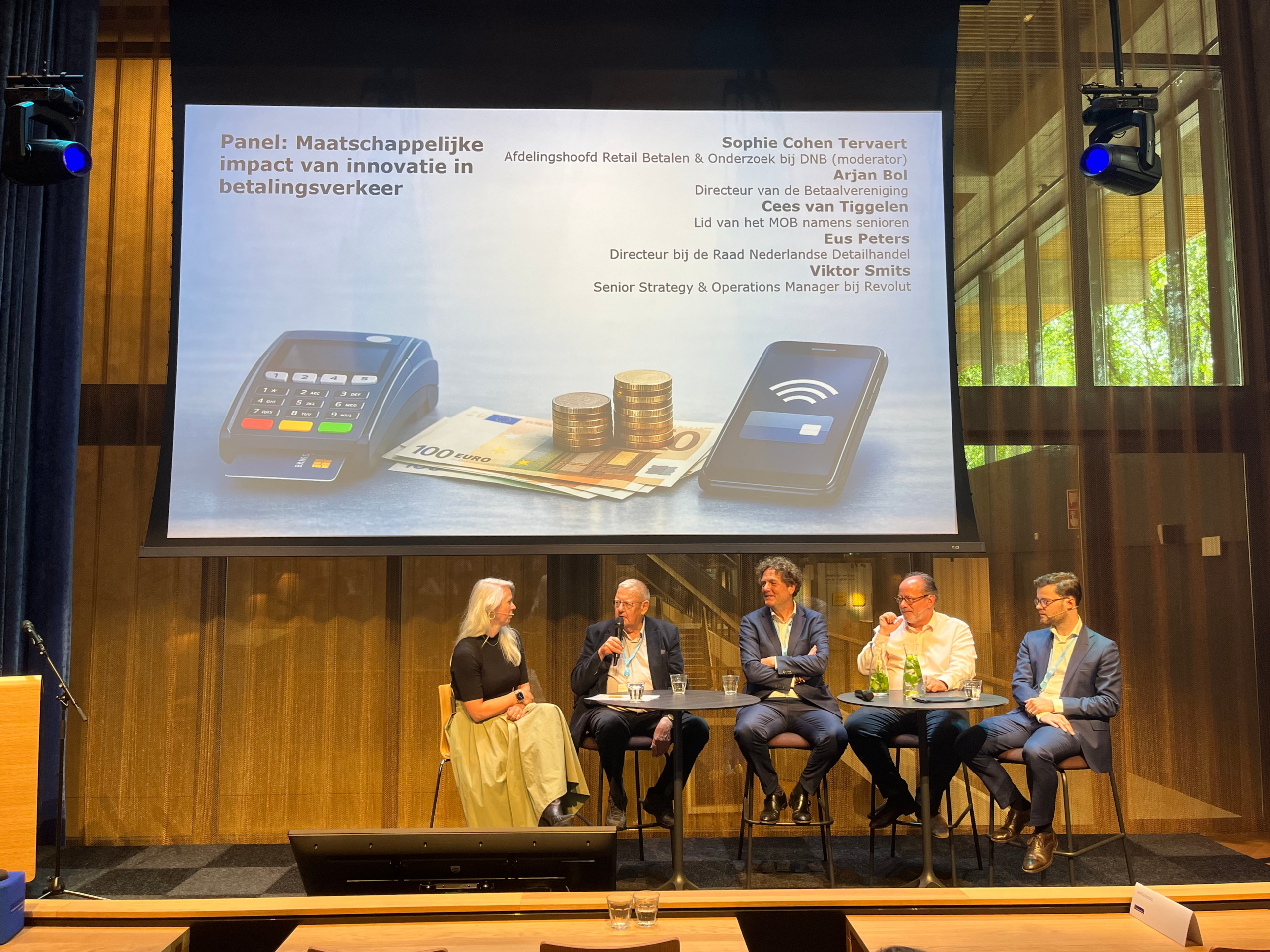 Panel over maatschappelijke impact van innovatie in betalingsverkeer met pinterminal, contant geld en smartphone op het scherm.