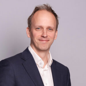 Business portrait of Kevin Meijer wearing a blazer and white shirt against a neutral background.
