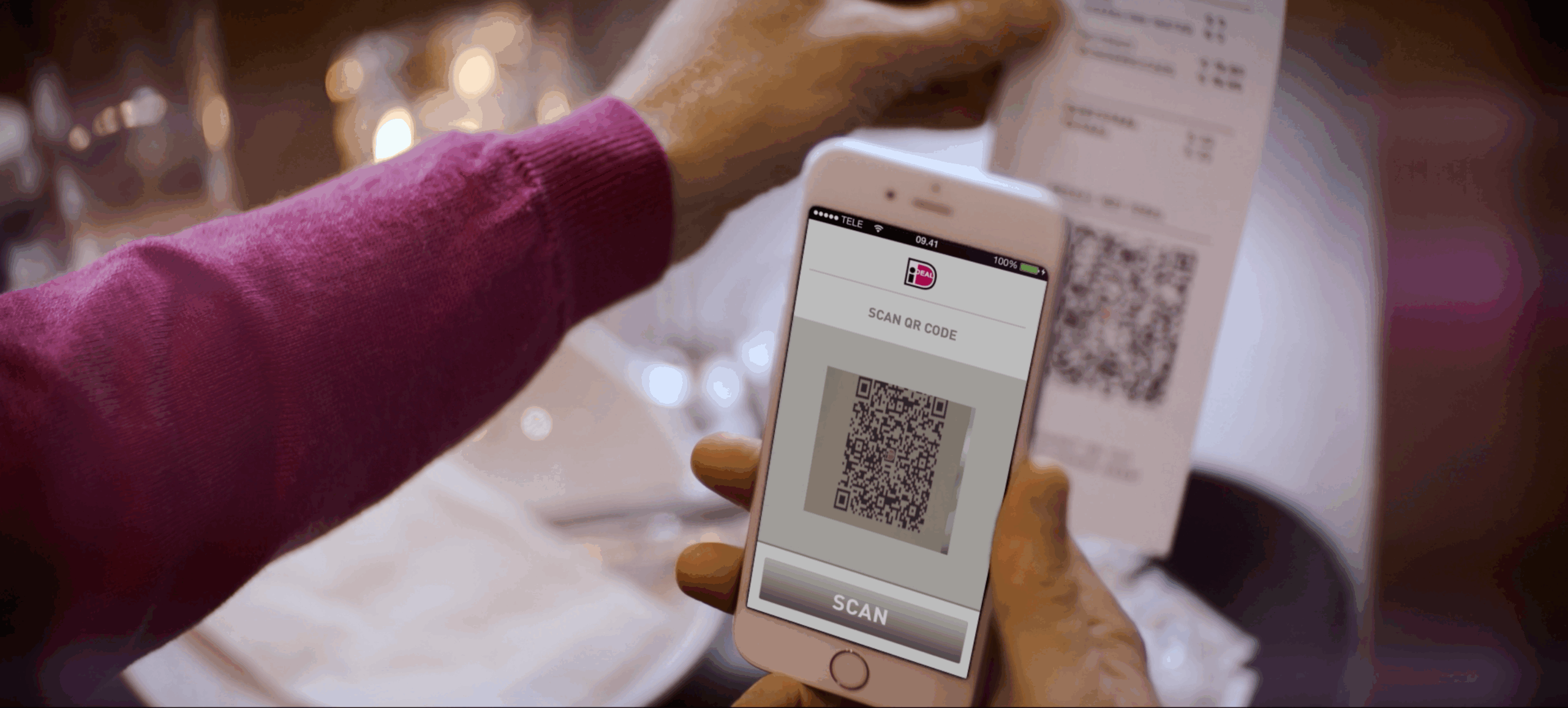 Klant scant iDEAL-QR-code op restaurantrekening met smartphone om direct mobiel af te rekenen.